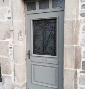 Porte d'entrée bois avec finition RAL, grille fer forgée et imposte fixe 3 carreaux.